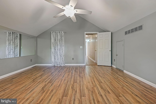 interior space with baseboards, visible vents, vaulted ceiling, and light wood-style floors