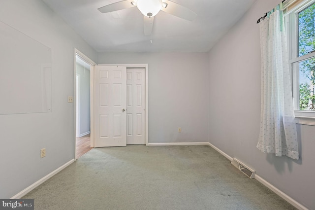 unfurnished bedroom with a closet, baseboards, carpet flooring, and visible vents