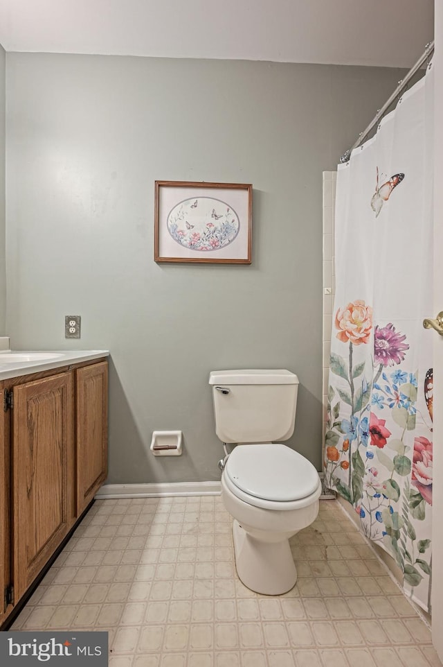 full bathroom featuring a shower with curtain, tile patterned floors, baseboards, vanity, and toilet