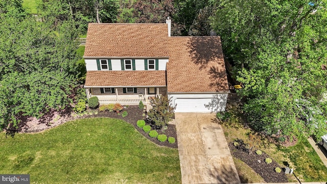 view of front of home with a porch, a garage, a front yard, and concrete driveway