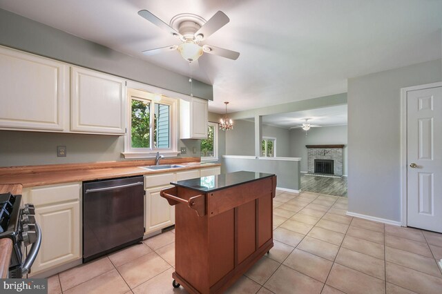 kitchen with stainless steel dishwasher, a center island, ceiling fan with notable chandelier, and gas range