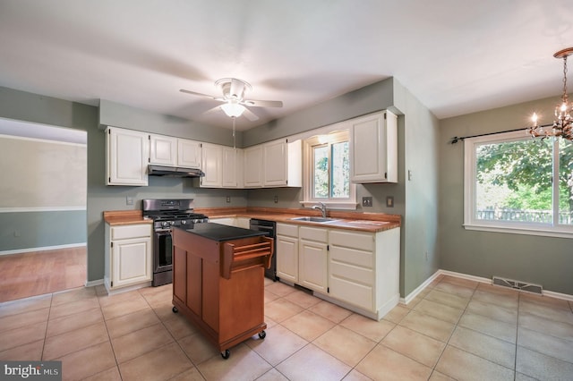 kitchen featuring visible vents, stainless steel gas range oven, white cabinets, dishwashing machine, and under cabinet range hood