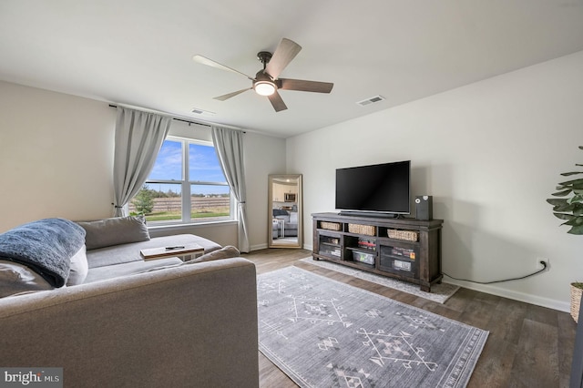 living room with ceiling fan, baseboards, wood finished floors, and visible vents