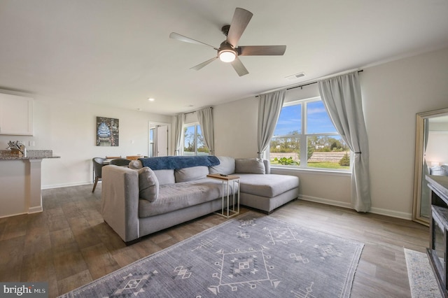 living area featuring recessed lighting, dark wood-style floors, visible vents, a ceiling fan, and baseboards