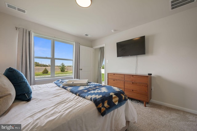 bedroom featuring light colored carpet, baseboards, and visible vents