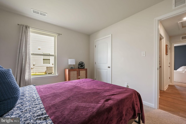 carpeted bedroom featuring baseboards and visible vents