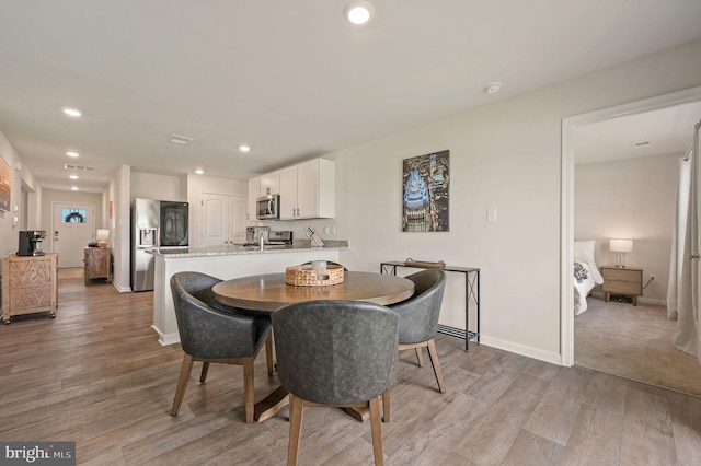 dining space with baseboards, light wood-style floors, visible vents, and recessed lighting