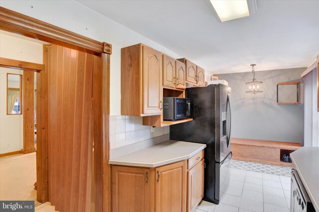 1205 Bridge St, New Cumberland, PA 17070 - kitchen with light countertops, stainless steel fridge, light tile patterned floors, a chandelier, and backsplash