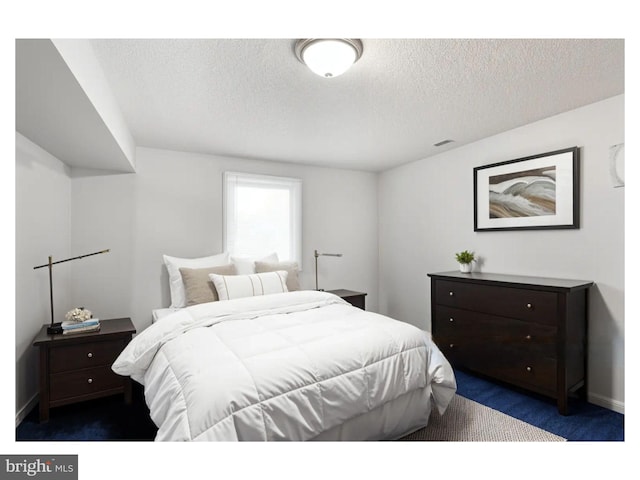 carpeted bedroom featuring visible vents, a textured ceiling, and baseboards