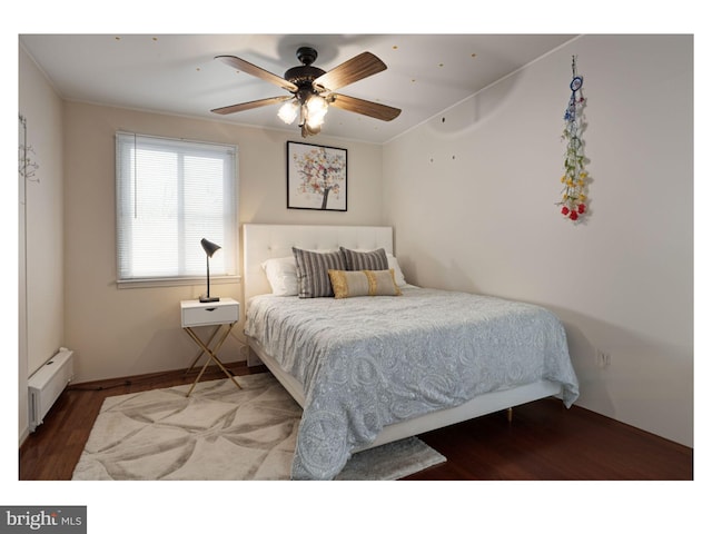 bedroom with a baseboard radiator, a ceiling fan, and wood finished floors