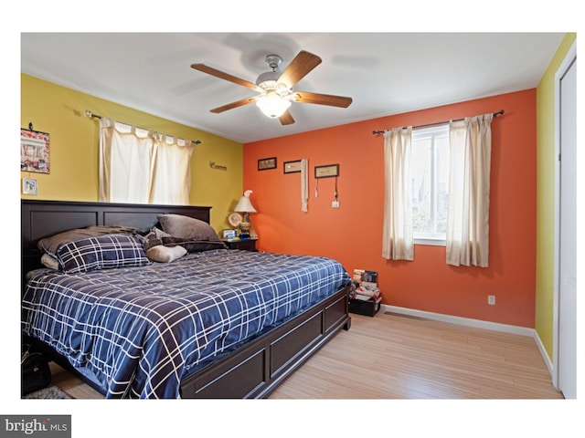 bedroom featuring light wood-type flooring, baseboards, and ceiling fan