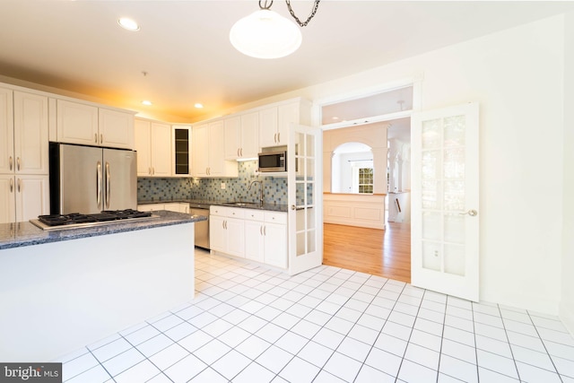 6038 Kelsey Ct, Falls Church, VA 22044 - kitchen featuring stainless steel appliances, tasteful backsplash, a sink, and light tile patterned flooring