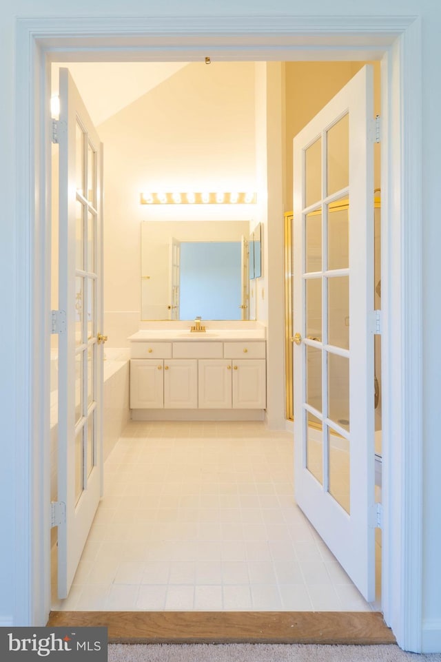 6038 Kelsey Ct, Falls Church, VA 22044 - bathroom with a bathing tub, vanity, french doors, tile patterned floors, and lofted ceiling