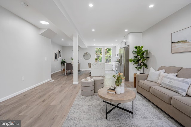 living room with recessed lighting, baseboards, and light wood finished floors