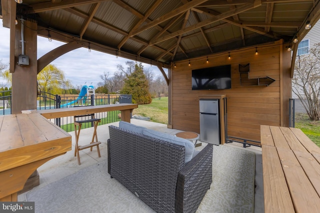 view of patio / terrace featuring a playground, fence, a gazebo, and outdoor lounge area