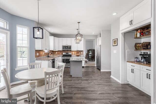 dining space with recessed lighting, dark wood finished floors, and baseboards