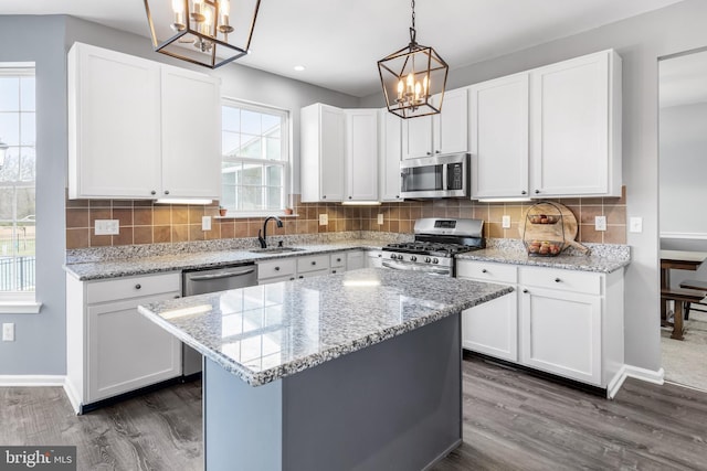 kitchen with stainless steel appliances, a chandelier, dark wood-style floors, a sink, and recessed lighting