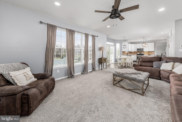 living area with ceiling fan, recessed lighting, baseboards, and light carpet