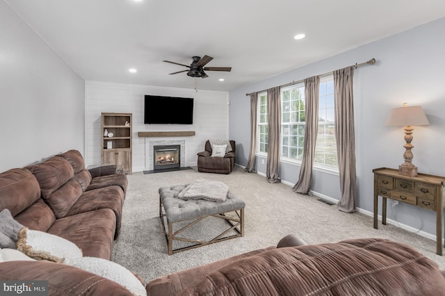 carpeted living room with ceiling fan, baseboards, recessed lighting, and a fireplace with flush hearth