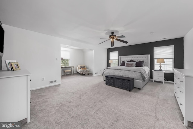 bedroom featuring multiple windows, light carpet, and ceiling fan