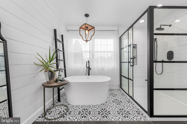 full bathroom with a shower stall, a freestanding bath, tile patterned floors, and recessed lighting