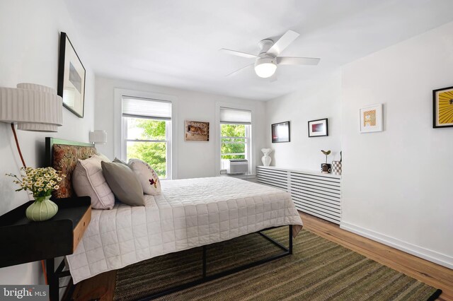 bedroom with wood finished floors, baseboards, and a ceiling fan