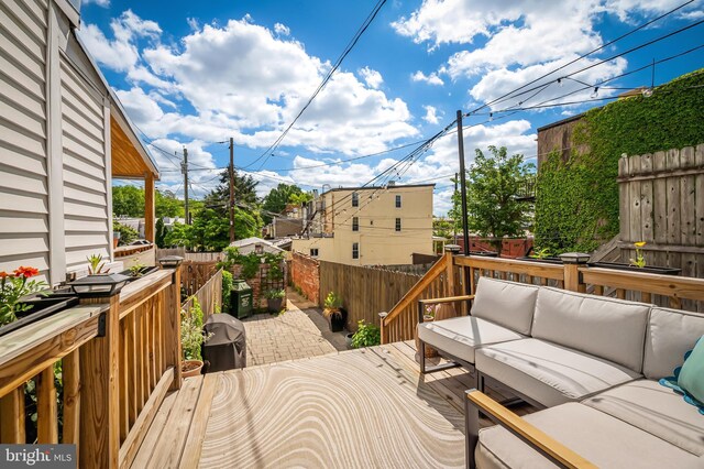 deck featuring an outdoor living space and a fenced backyard