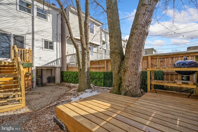 wooden terrace featuring central air condition unit and fence