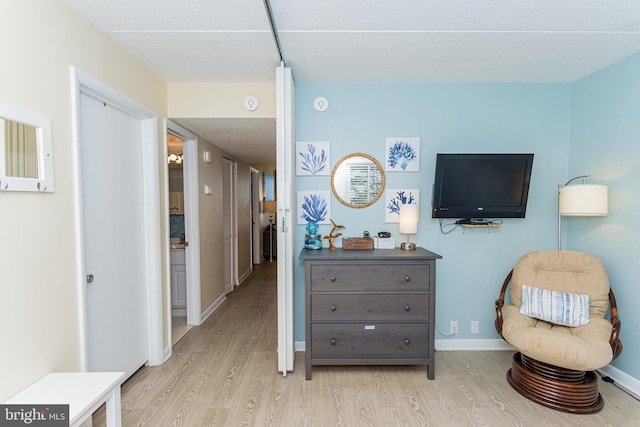 11500 Coastal Hwy Unit 317, Ocean City, MD 21842 - living area featuring baseboards, light wood-type flooring, and a textured ceiling