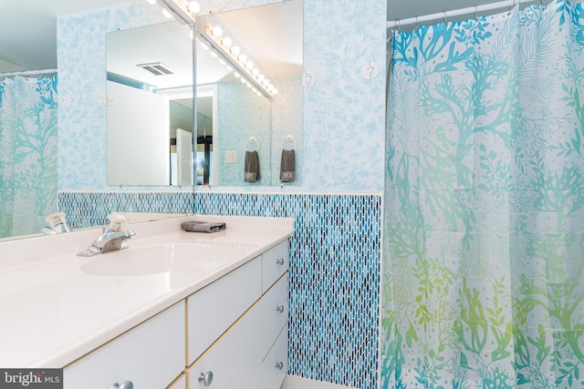 11500 Coastal Hwy Unit 317, Ocean City, MD 21842 - full bathroom with vanity, wallpapered walls, a wainscoted wall, visible vents, and tile walls