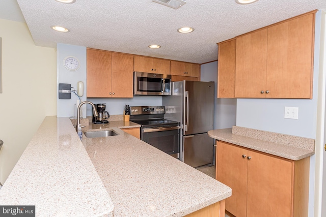 11500 Coastal Hwy Unit 317, Ocean City, MD 21842 - kitchen with visible vents, a sink, appliances with stainless steel finishes, a peninsula, and a textured ceiling