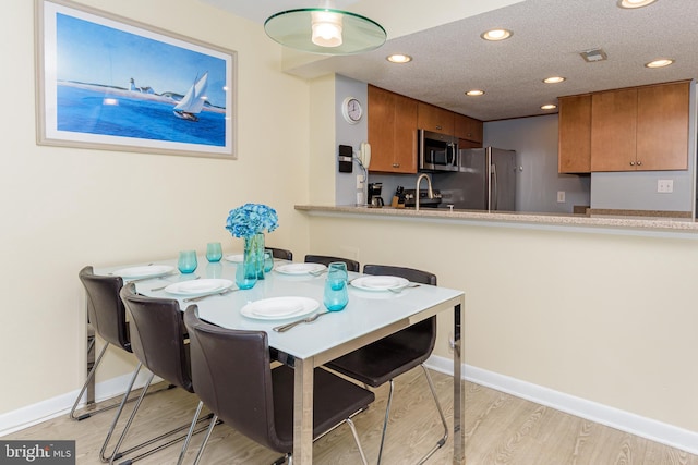 11500 Coastal Hwy Unit 317, Ocean City, MD 21842 - dining room featuring light wood-style floors, visible vents, a textured ceiling, and baseboards