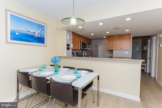 11500 Coastal Hwy Unit 317, Ocean City, MD 21842 - dining area with baseboards, light wood-type flooring, and a textured ceiling