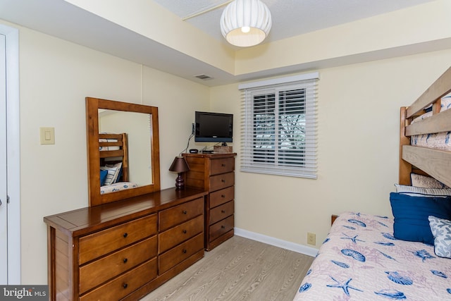 11500 Coastal Hwy Unit 317, Ocean City, MD 21842 - bedroom featuring light wood-style flooring, a raised ceiling, baseboards, and visible vents