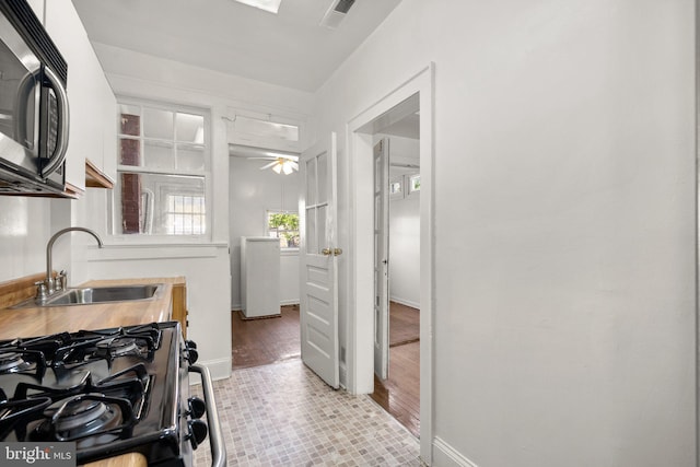 560 25th Pl NE, Washington, DC 20002 - kitchen with ceiling fan, visible vents, a sink, gas stove, and baseboards
