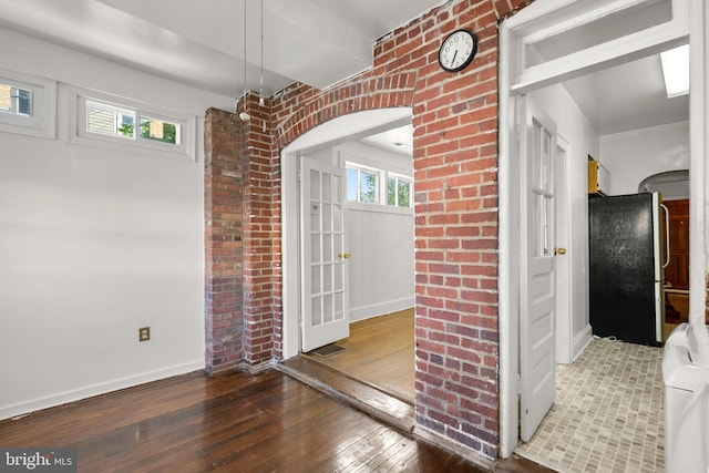 560 25th Pl NE, Washington, DC 20002 - unfurnished dining area with arched walkways, baseboards, brick wall, and hardwood / wood-style floors