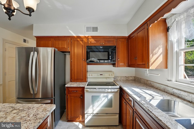 kitchen featuring visible vents, freestanding refrigerator, a chandelier, black microwave, and white range with electric stovetop