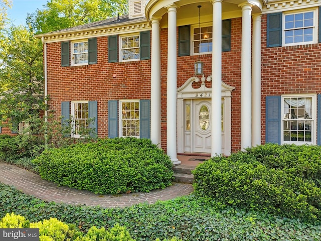 entrance to property featuring brick siding