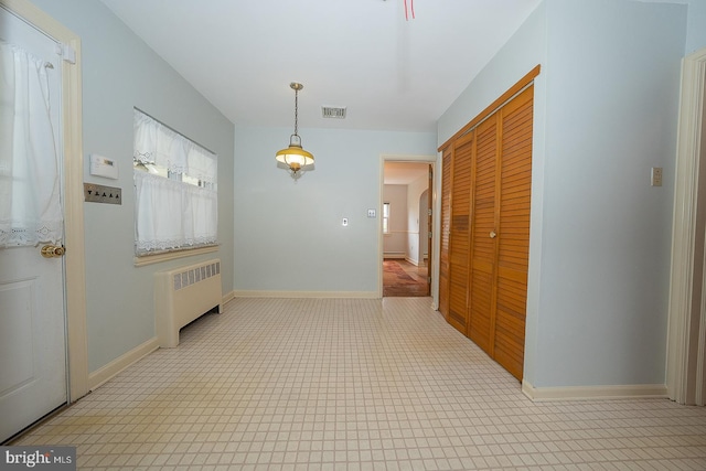 corridor featuring a baseboard heating unit, baseboards, and radiator heating unit