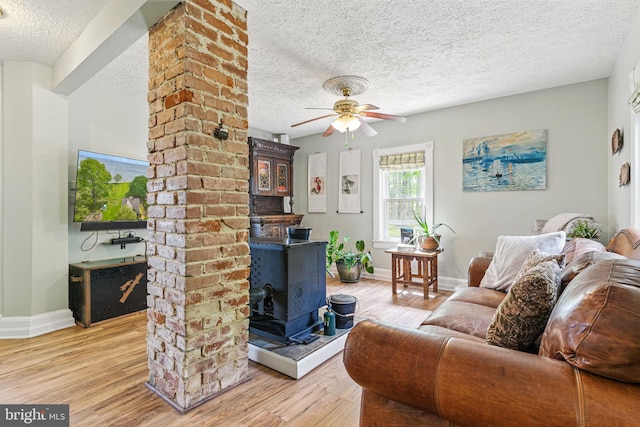 living area with a textured ceiling, light wood-style floors, and baseboards