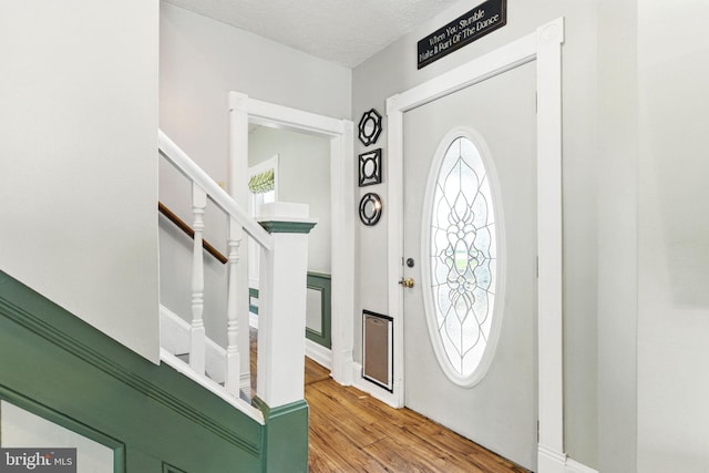entrance foyer featuring wood finished floors and stairs