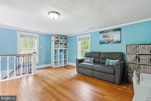 living room with hardwood / wood-style flooring, a wealth of natural light, and ornamental molding