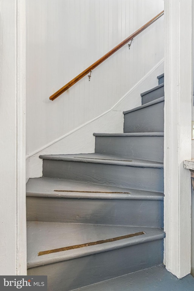 stairway featuring finished concrete floors