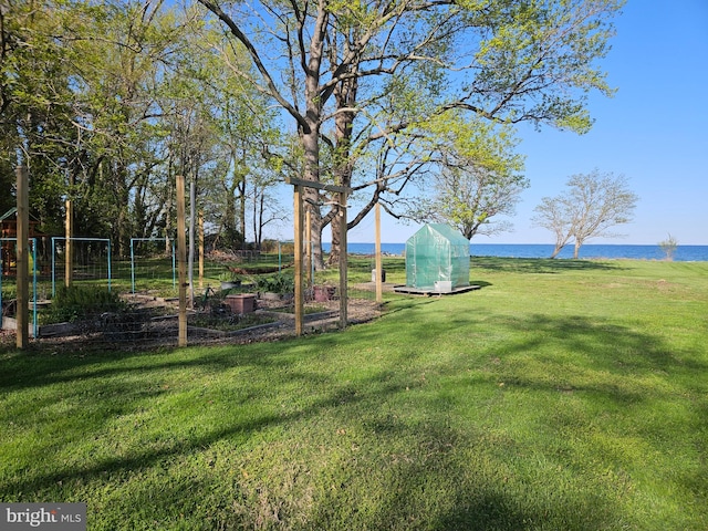 view of yard with a garden and a water view