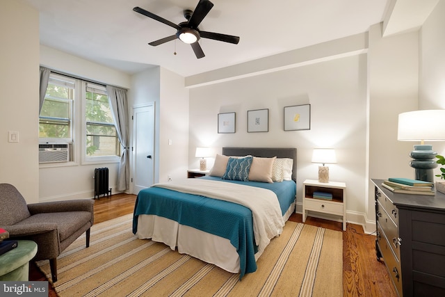 bedroom with radiator, baseboards, ceiling fan, cooling unit, and light wood finished floors