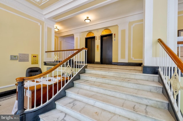 staircase with crown molding, elevator, and decorative columns