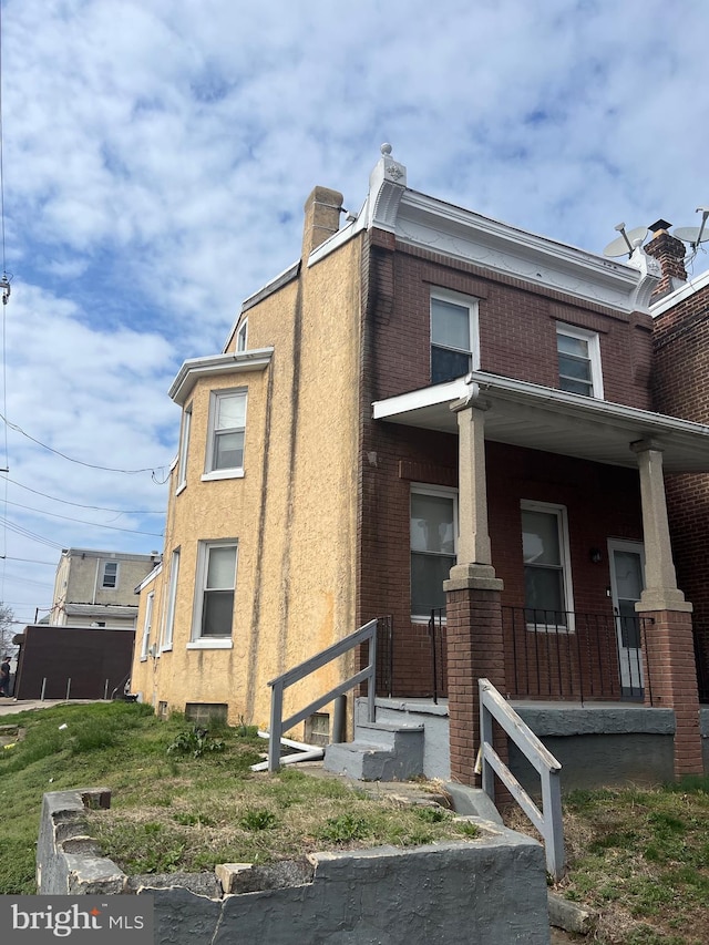 6700 Marsden St, Philadelphia, PA 19135 - view of front of house with a chimney, brick siding, and a porch