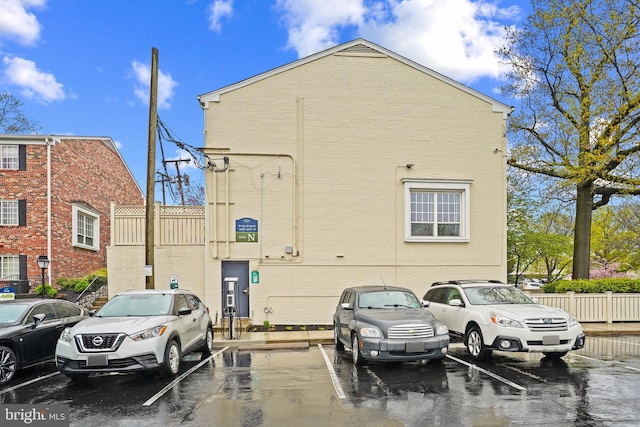 view of side of property featuring brick siding and uncovered parking