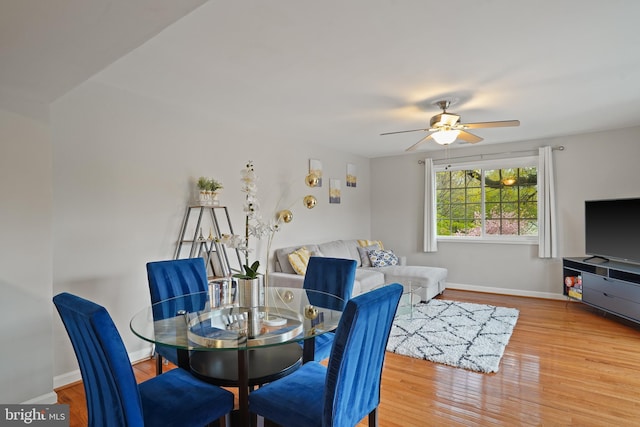 dining room with baseboards, ceiling fan, and wood finished floors