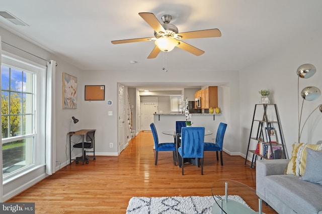 dining space featuring ceiling fan, light wood finished floors, baseboards, and visible vents